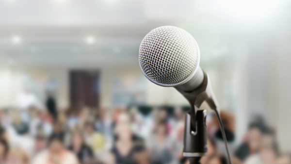 Image of microphone and blurred audience in background